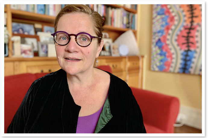 A middle aged woman with glasses looking at the camera