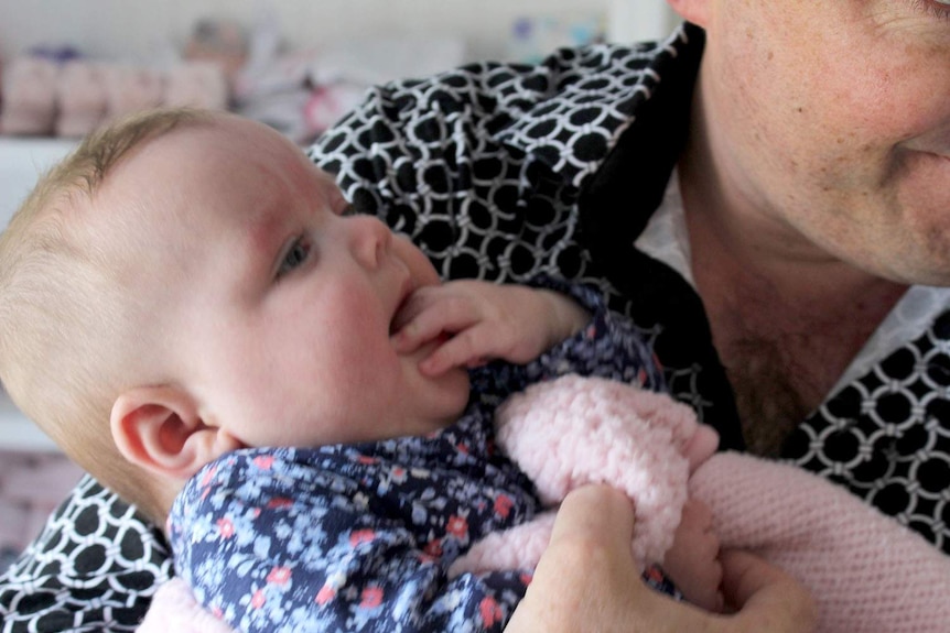 Six-month-old Adaline is cradled by her father David Seddon.