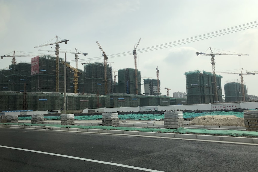 A dozen apartment towers are under construction, and they are accompanied by dozens of cranes.