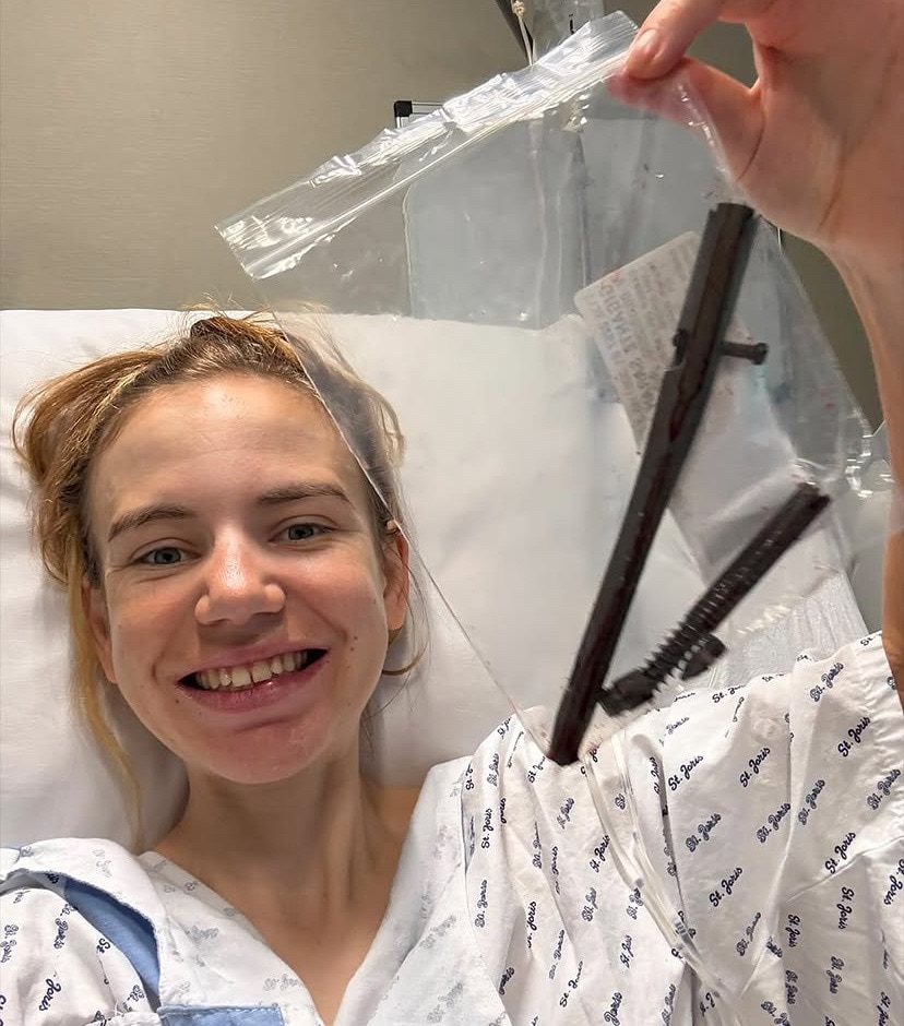 Sarah Gigante holds up two pins and smiles