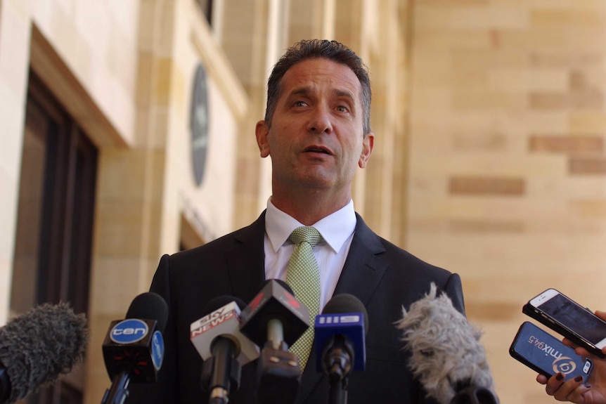 Upshot of Paul Papalia in front of microphones outside Parliament House.