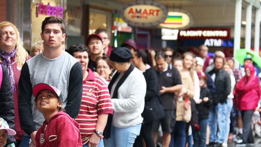 A long queue of people waiting to meet Queensland Maroons players