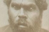 A black and white headshot of an Indigenous man with a beard
