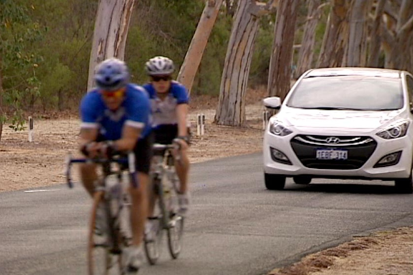 Two cyclists on road with car about to overtake