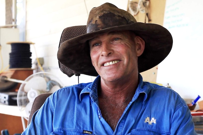 Steve Hagan sitting down, wearing a large cattleman's hat and smiling at the camera.