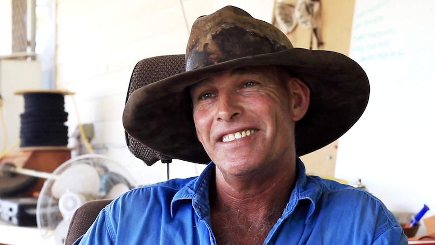 Steve Hagan sitting down, wearing a large cattleman's hat and smiling at the camera.