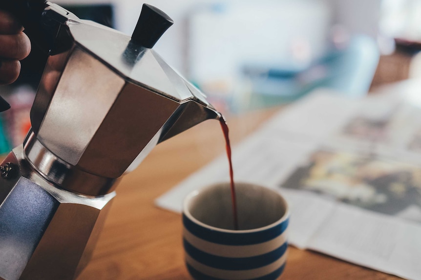 A person pours coffee into a cup.