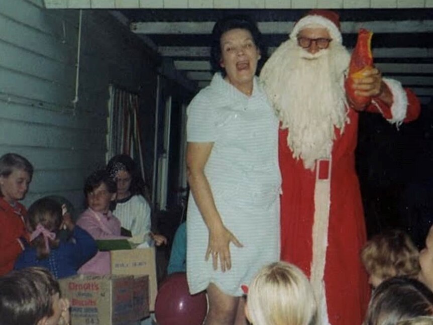 a woman smiling next to santa