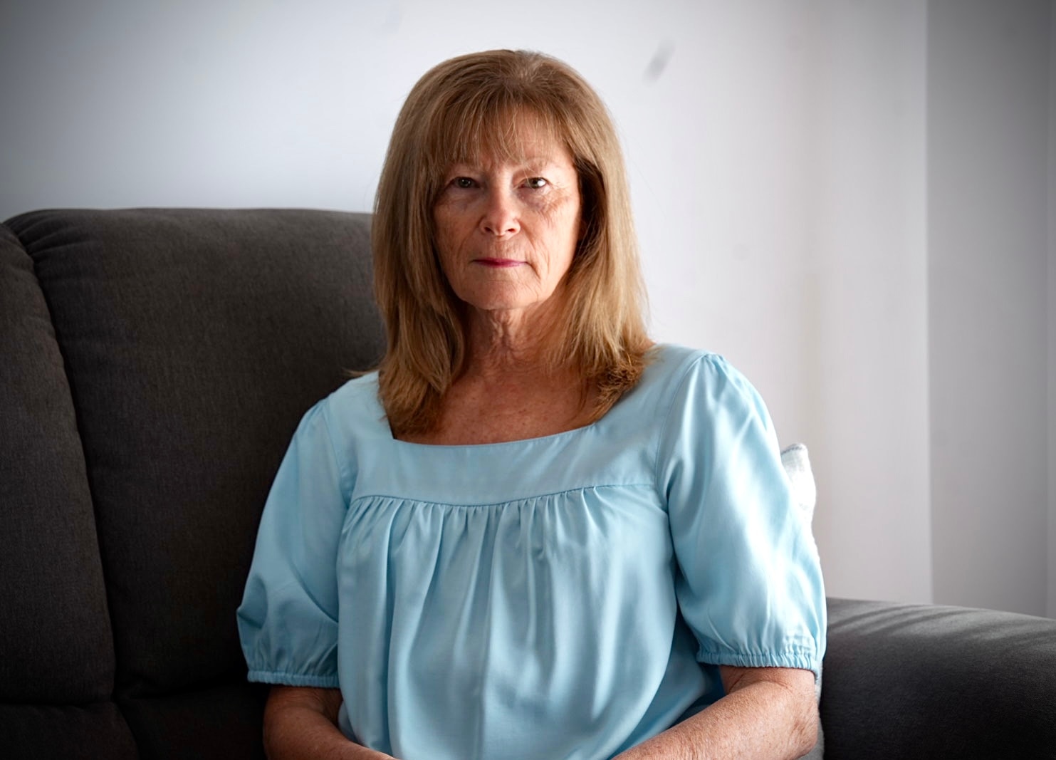 A strawberry blonde haired woman in a blue shirt.