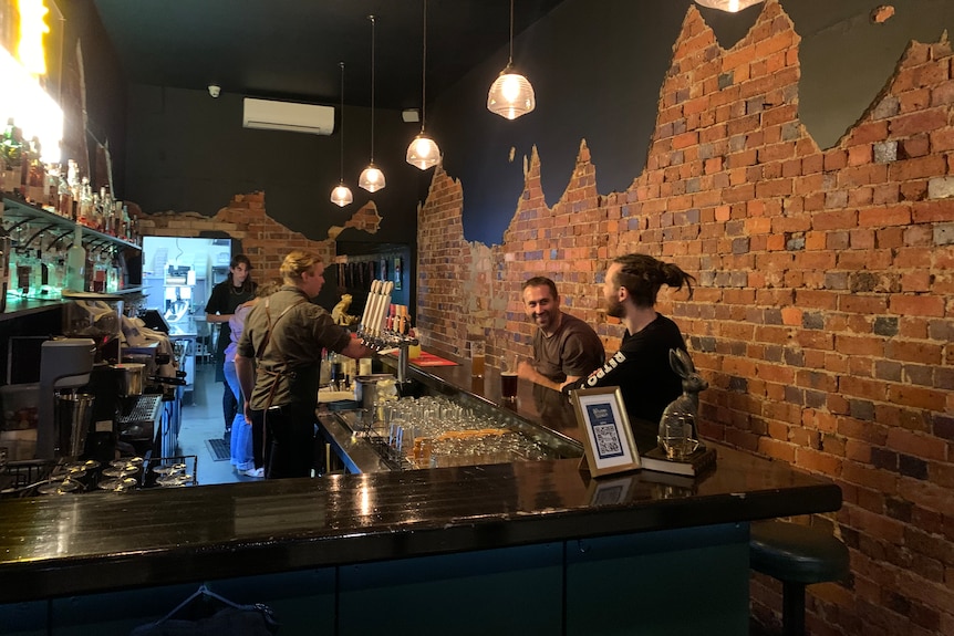 long bar with with two men sitting and talking