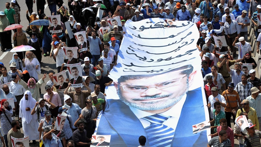 Supporters of the deposed president Mohamed Morsi carry a giant poster bearing his portrait during a 2013 demonstration.