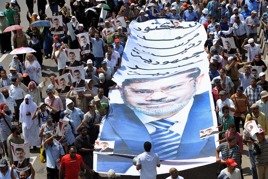 Mohamed Morsi protesters carry posters in street