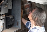 Sydney retiree Merinda Air looking inside her home's energy box