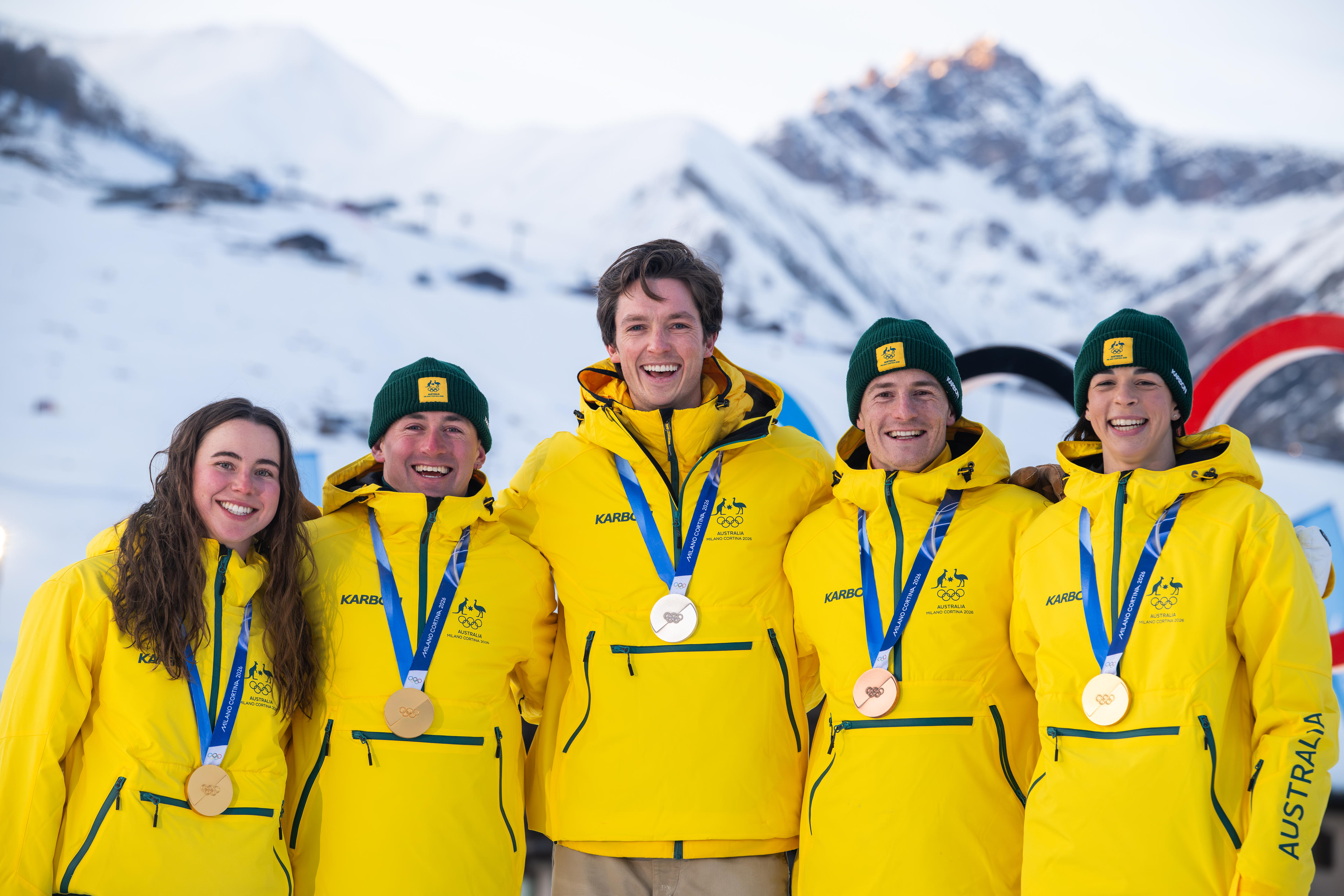 Jakara Anthony, Josie Baff, Cooper Woods, Matt Graham and Scotty James stand in front of the Olympic rings.