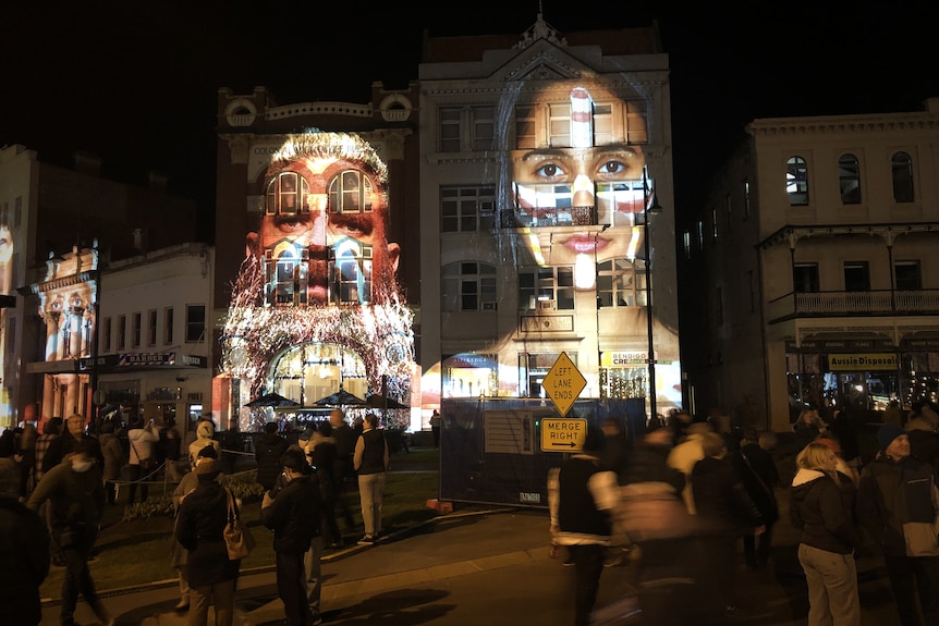 two aboriginal people are displayed on a building