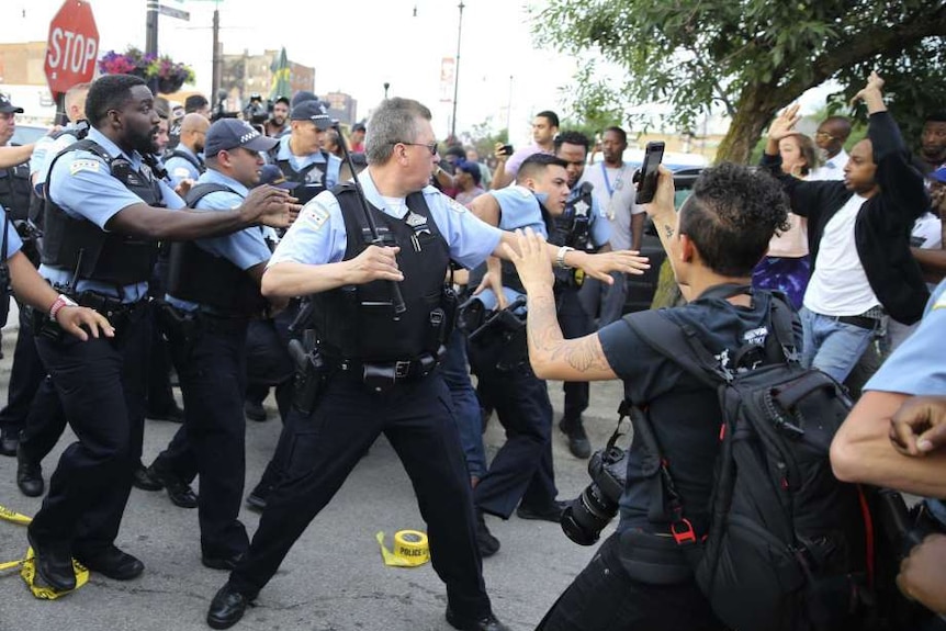 Police raise batons at group of protesters