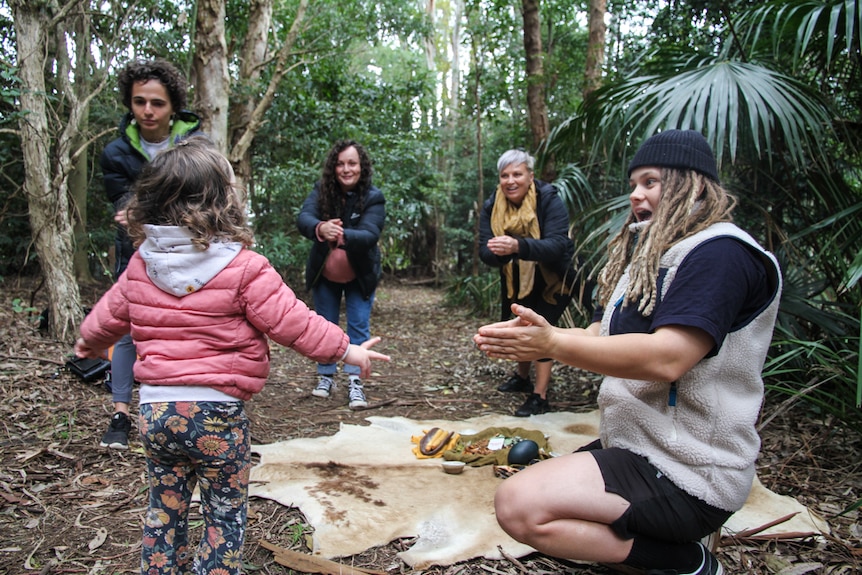 Four women and a small child practice the Aboriginal modality, Wayapa Wuurrk. 