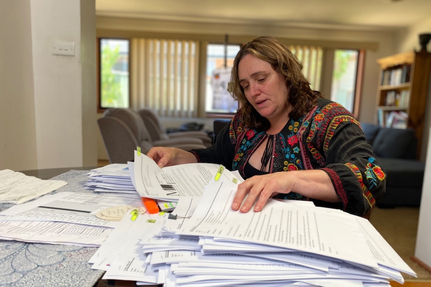 Woman looking at a large pile of documents 