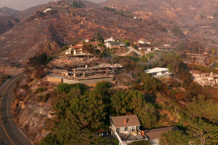 An aerial view of a home destroyed by fire while the neighbouring properties remain standing.