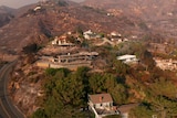 An aerial view of a home destroyed by fire while the neighbouring properties remain standing.