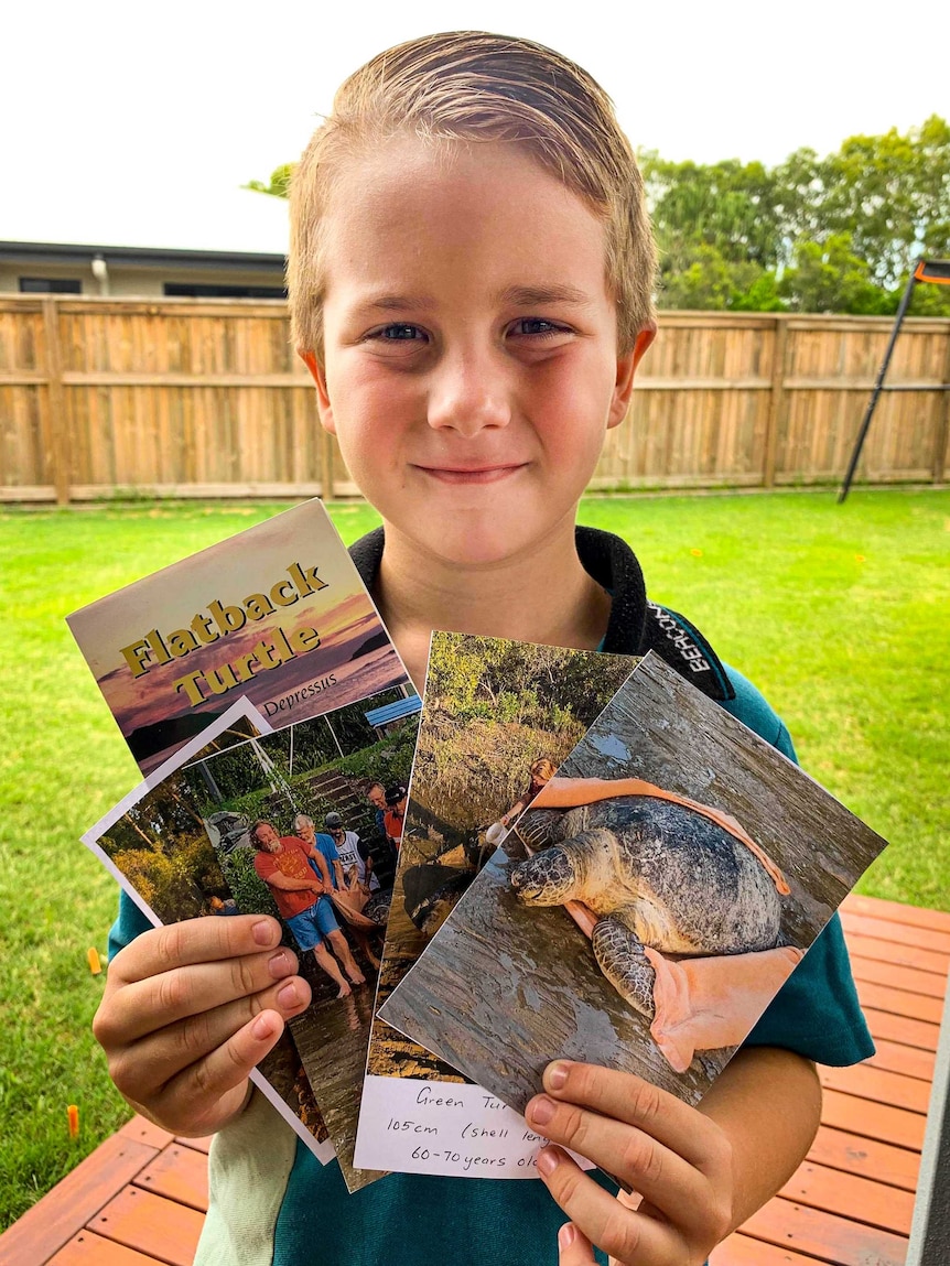 Findlay Woods holding photos of the rescue and flyers he was given by Turtlewatch.
