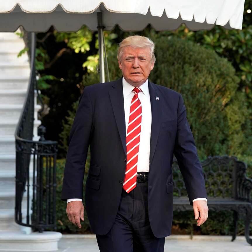 US President Donald Trump walks out from the White House.
