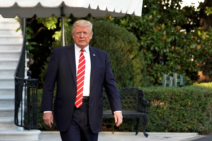 US President Donald Trump walks out from the White House.