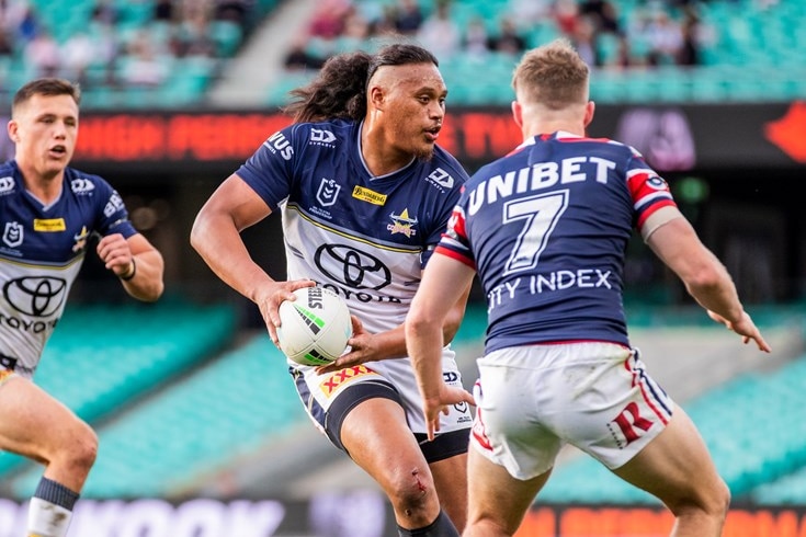 A North Queensland Cowboys player holding a football while running