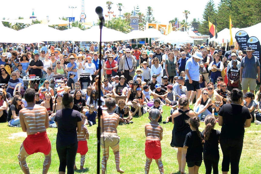 Aboriginal dancers perform in front of a crowd outside at the festival.