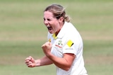 Australian bowler Sophie Molineux pumps her fist in the middle of the pitch.