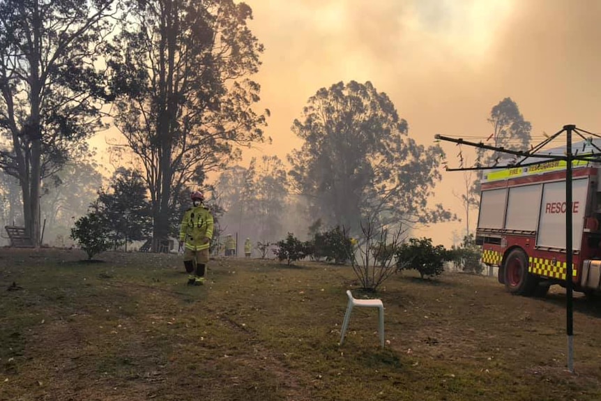 A firefighter walks near a fire truck ahead of a bushfire.