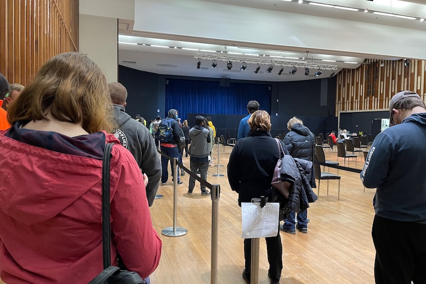 People standing inside a convention centre.