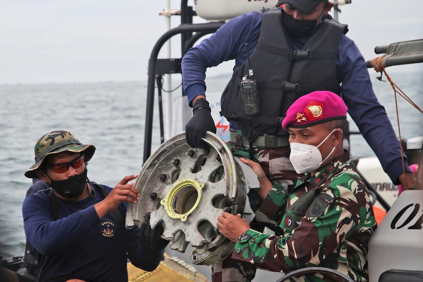 인도네시아 해군 잠수부들이 수중에서 회수한 항공기 부품을 전시하고 있다.
