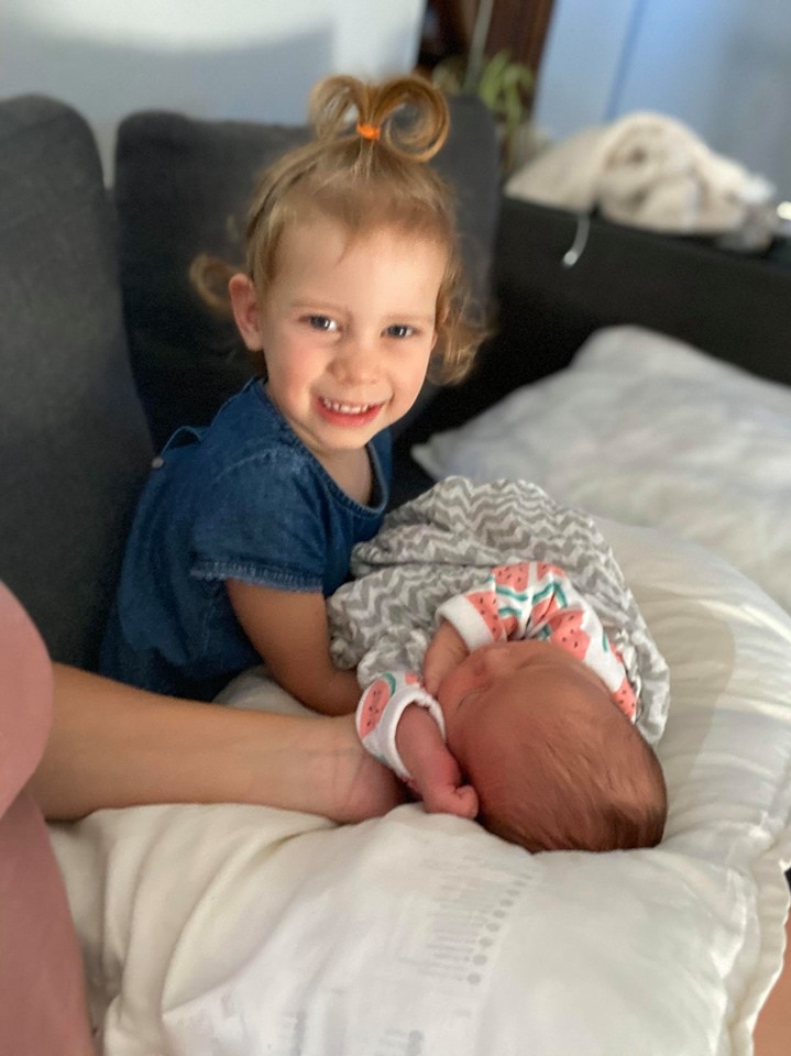 Young girl cradles newborn baby