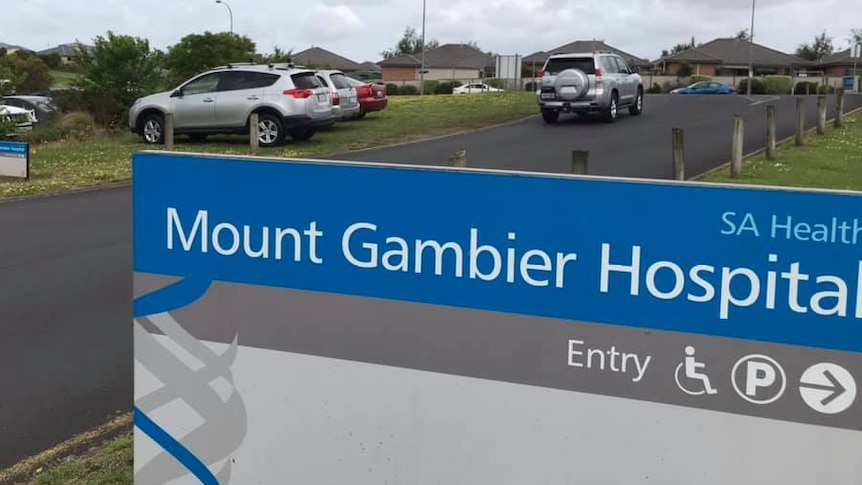 A sign that read 'Mount Gambier Hospital' stands in front of a carpark on an overcast day.