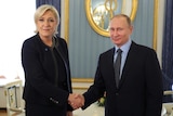 Russian President Vladimir Putin shakes hands with Marine Le Pen