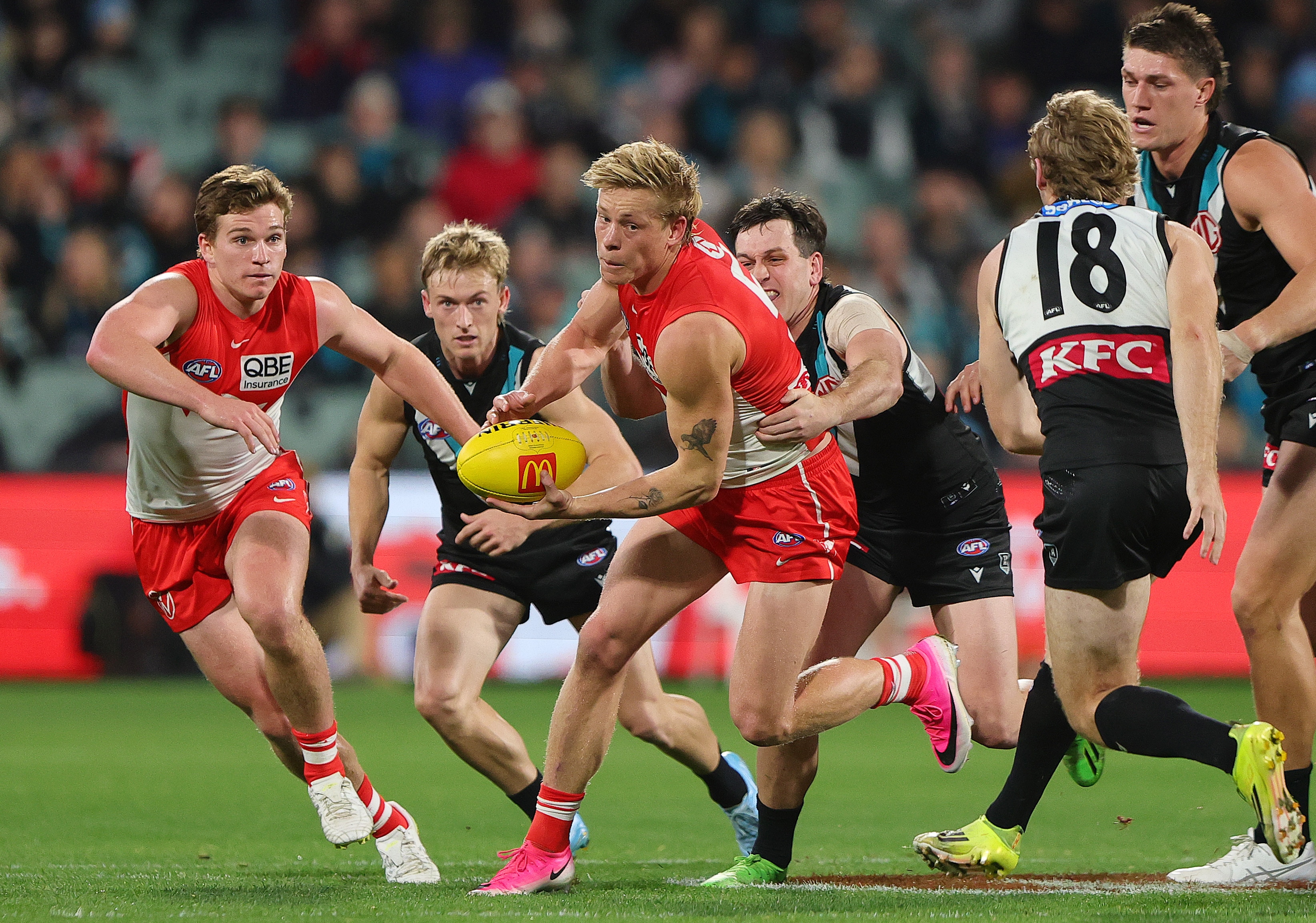 Isaac Heeney handballs while being tackled