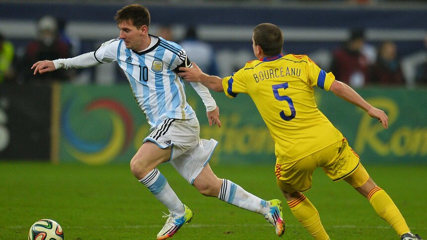 Lionel Messi takes on Romania's defence