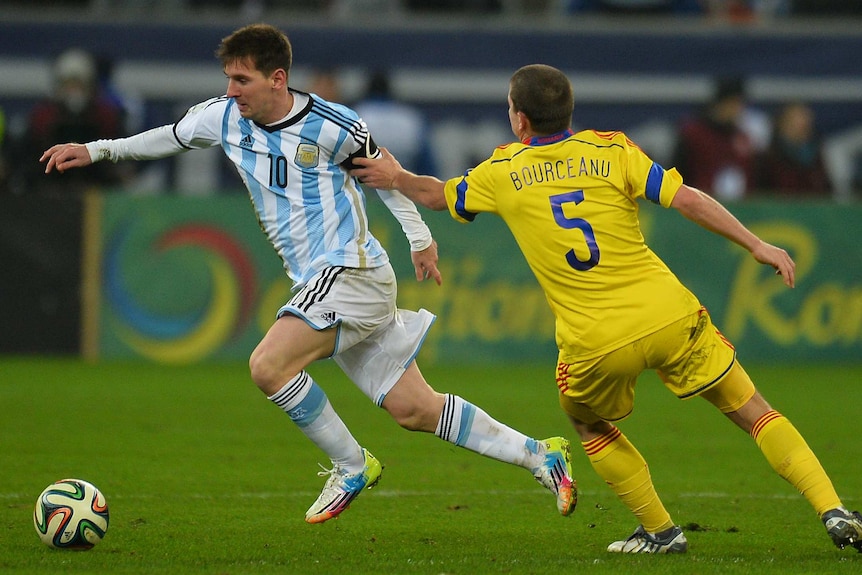 Lionel Messi takes on Romania's defence