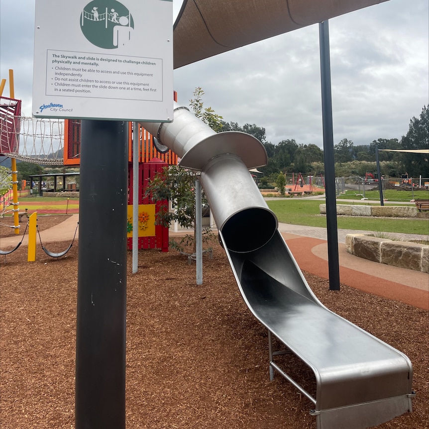 A tubular metal slide at a playground.