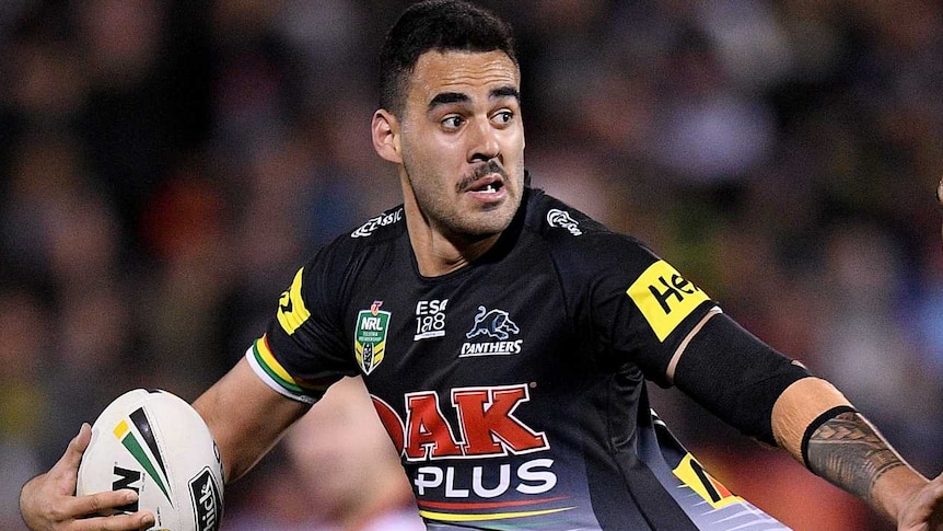 Penrith Panthers player Tyrone May is caught by Warriors defender Peta Hiku during an NRL game.