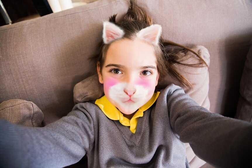 Girl on phone posing with kitten face