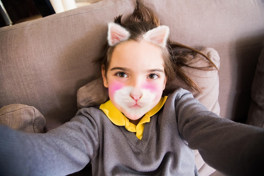 Girl on phone posing with kitten face