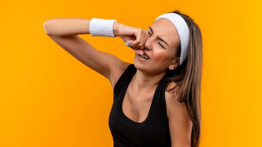 A young woman wearing a black singlet and white sweatbands crying