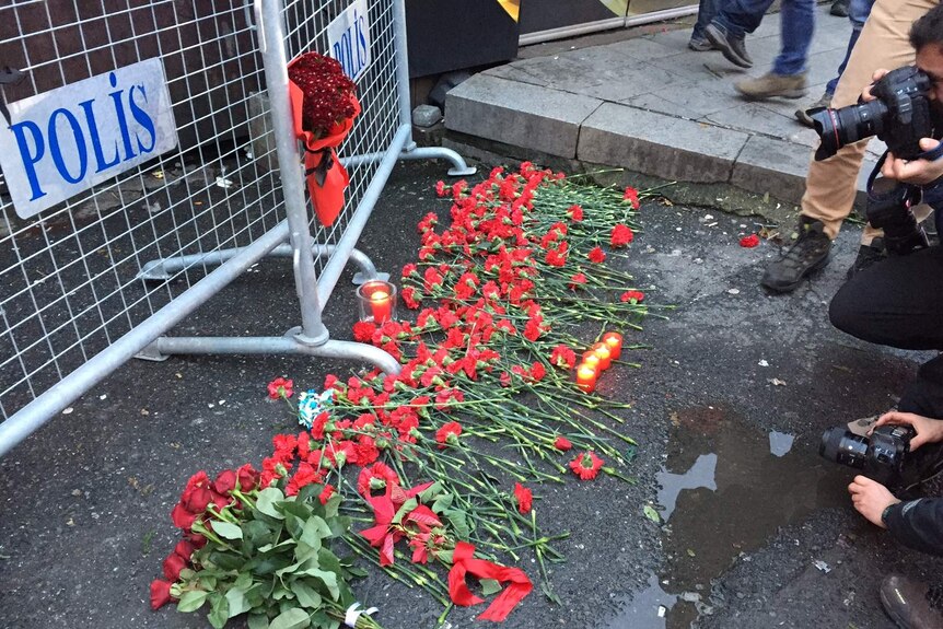 People leave flowers for the victims outside the Reina nightclub