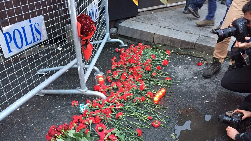 People leave flowers for the victims outside the Reina nightclub