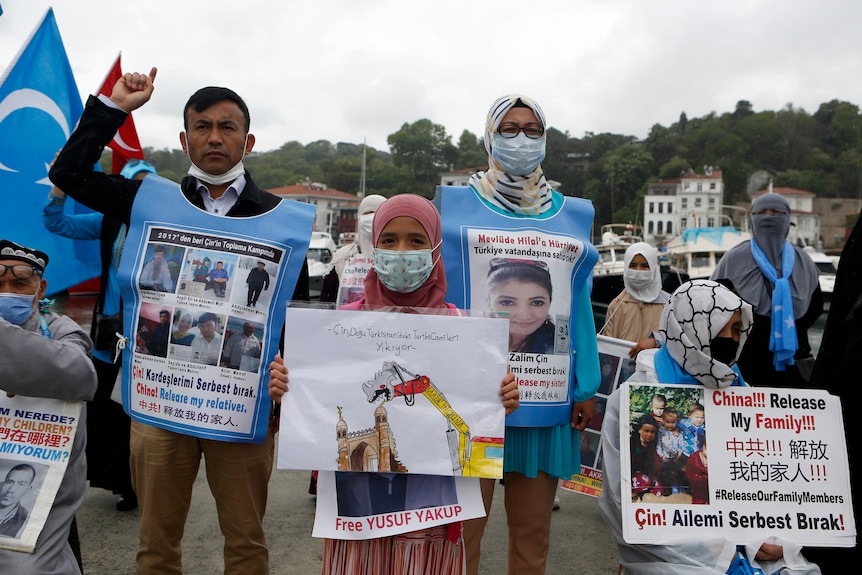 Members of the Uyghur community in Turkey hold placards during a protest outside the Chinese consulate