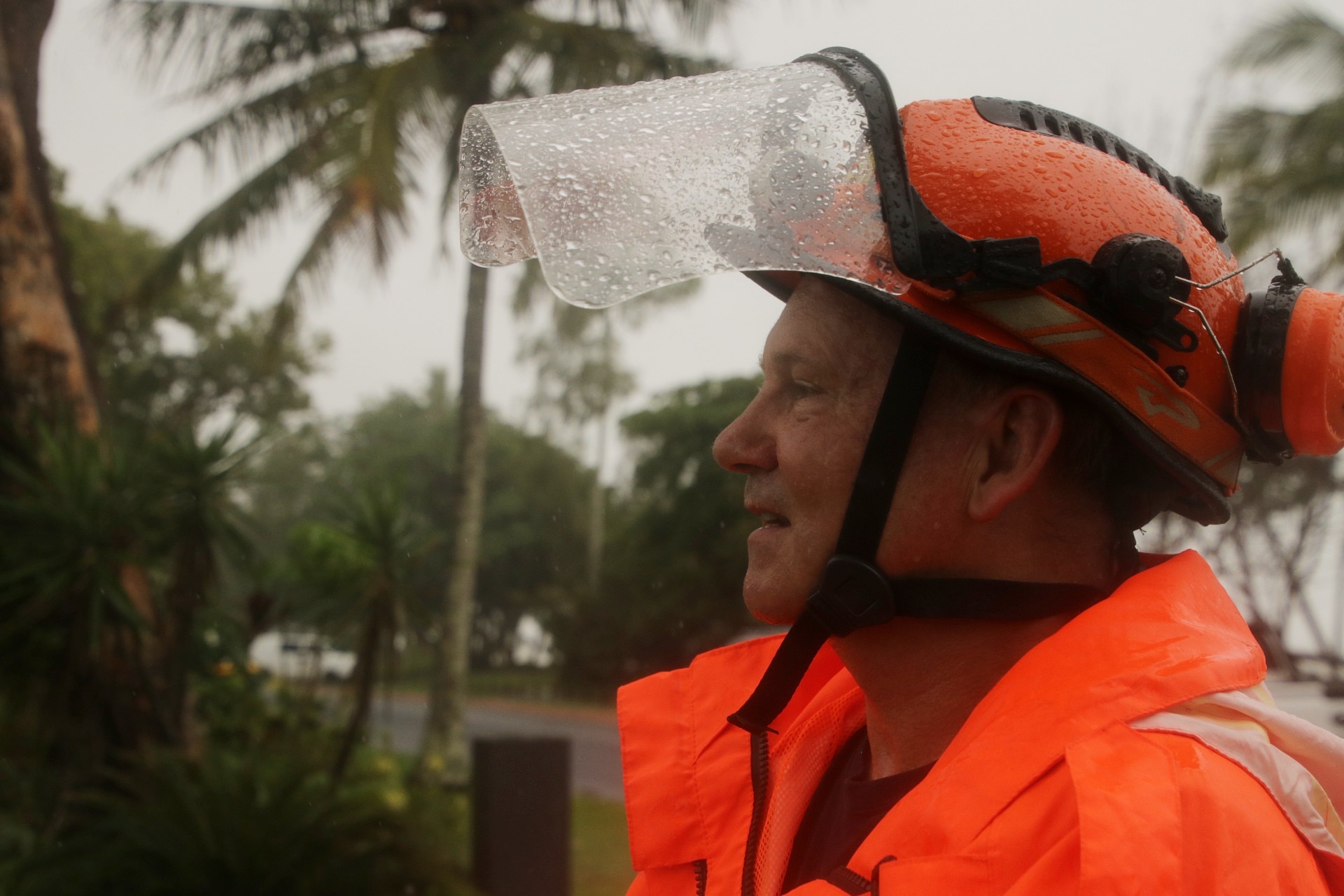 homem de uniforme olhando para fora, está chovendo