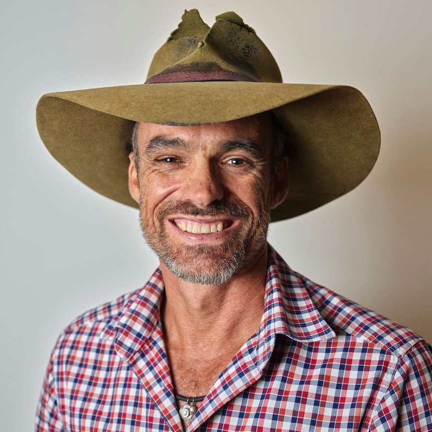 NT photographer and Smith St Mall businessowner Paul Arnold smiling and wearing a worn bush hat