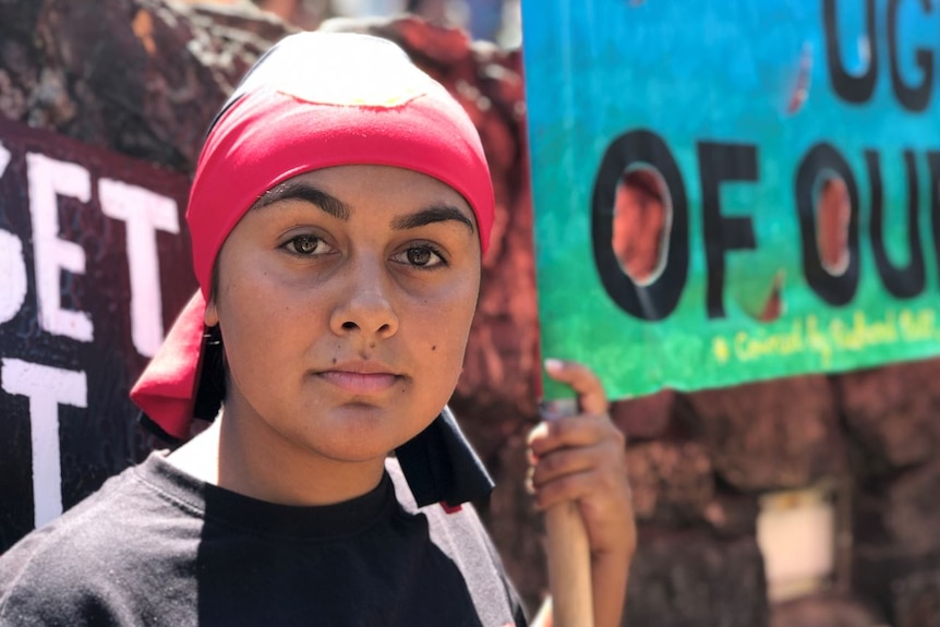 A woman wearing a headband with the Aboriginal flag on it.